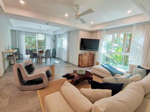 a living room with a couch and chairs and a television at Elan at Ballena Beach in Uvita