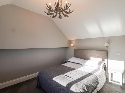 a bedroom with a bed and a chandelier at The Pheasantry in Scarborough