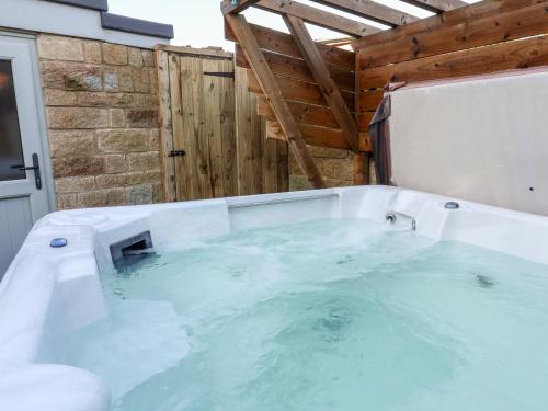 a jacuzzi tub in a room with a wooden wall at The Pheasantry in Scarborough