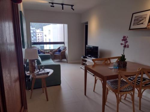 a living room with a table and chairs and a couch at Edifício Monte Carmel in Guarujá