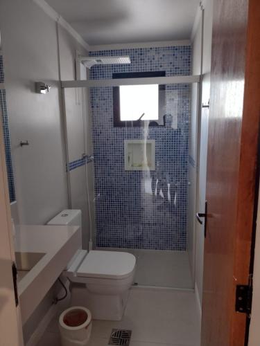 a small bathroom with a toilet and a shower at Edifício Monte Carmel in Guarujá