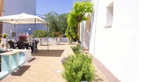 a patio with a table and chairs and plants at Trullo Nonna Rosa in Antonelli