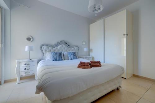 a white bedroom with a white bed with a white headboard at Seafront Apartment Sliema in Sliema