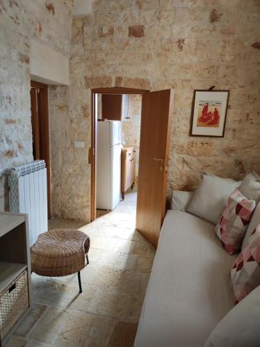 a living room with a couch and a refrigerator at Trullo Nonna Rosa in Antonelli
