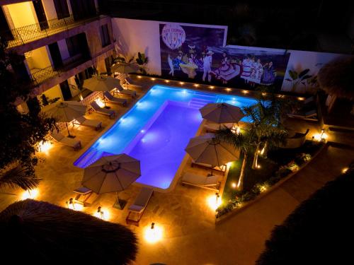 an overhead view of a pool with chairs and umbrellas at Hotel Camino Del Sol in Puerto Escondido