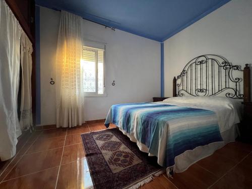 Schlafzimmer mit einem Bett und einem Fenster in der Unterkunft La Perla Azul in Chefchaouen