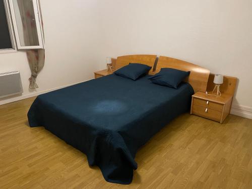 una camera da letto con un grande letto con copriletto blu di L’oustal a Vaudreuille