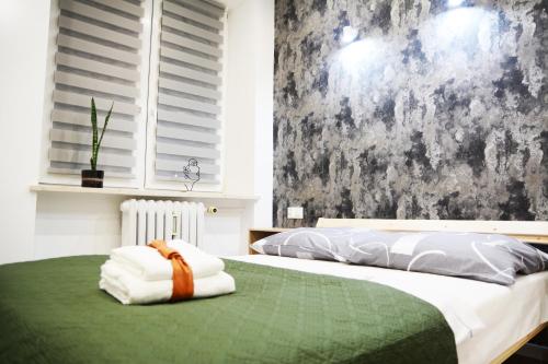 a bedroom with a bed with a green blanket at Apartment Le Château in Radom