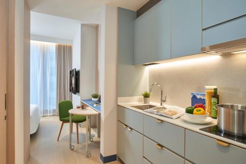 a kitchen with a sink and a table in a room at Citadines Raffles Place Singapore in Singapore
