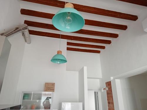a green light hanging from a ceiling in a kitchen at CAN LLAVI - TARTANA in Canet de Mar