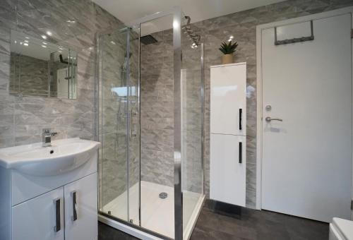 a bathroom with a glass shower and a sink at Perfectly located 4 bed town house in central Wetherby sleeps 8 in Wetherby