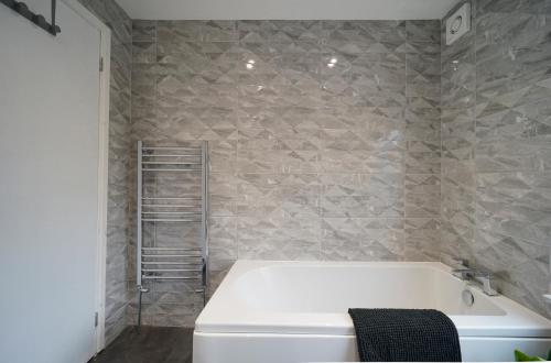 bagno con vasca bianca e parete in pietra di Perfectly located 4 bed town house in central Wetherby sleeps 8 a Wetherby