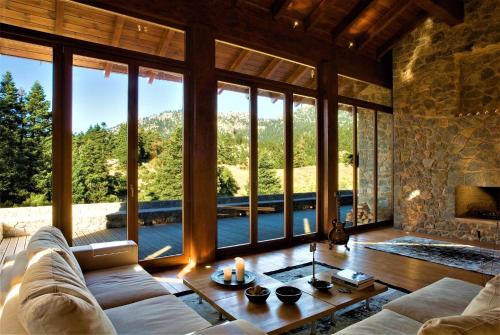 a living room with a couch and a large window at stodasos in Eptalofos