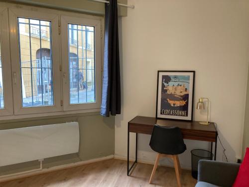 - un salon avec un bureau et une fenêtre dans l'établissement CARC'APPART Appartements à Carcassonne, à Carcassonne