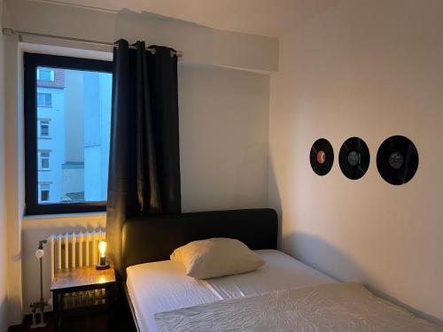 um quarto com uma cama e dois relógios na parede em Music Residence em Saarbrücken