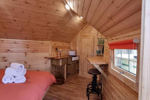 a bedroom with a bed in a wooden cabin at Woodland Cabin with Hot tub & log burner in Barmouth