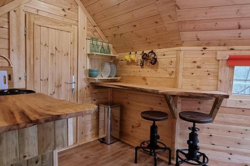 a kitchen with a bar in a wooden cabin at Woodland Cabin with Hot tub & log burner in Barmouth