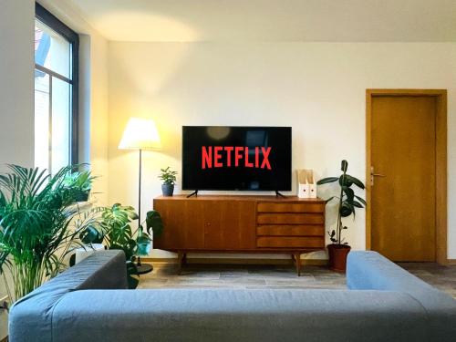 una sala de estar con TV con el cartel de netflix. en (PLANT ROOM 5) Mit Familie oder auch mit Freunde en Halle an der Saale