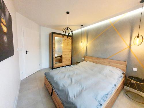 a bedroom with a large bed and a mirror at Konopnickiej 88 Cosy Apartment in Sosnowiec