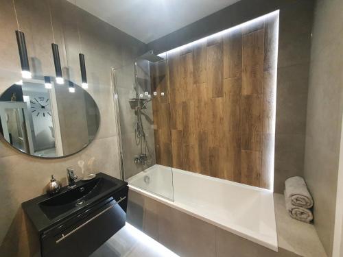 a bathroom with a sink and a mirror at Konopnickiej 88 Cosy Apartment in Sosnowiec