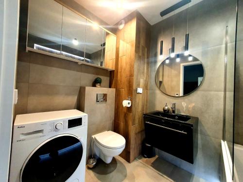 a bathroom with a washing machine and a sink at Konopnickiej 88 Cosy Apartment in Sosnowiec