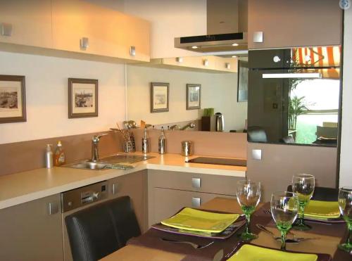 - une cuisine avec une table et des verres à vin dans l'établissement CANNES Front de Mer - Appartement 3 STAR, à Cannes