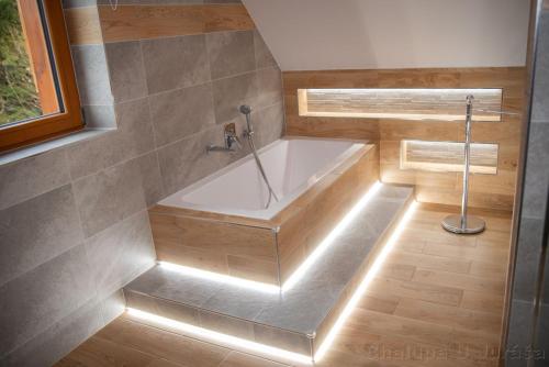 a bathroom with a bath tub with lights in it at Chalupa U Juráša in Horní Bečva