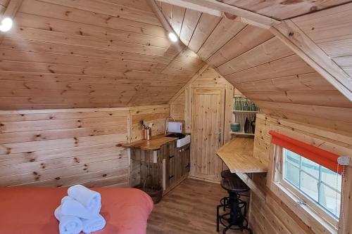 a log cabin bedroom with a bed and a desk at Tree Top Cabin with log burner & private hot tub in Barmouth
