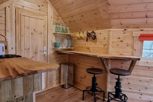 a kitchen with a bar in a wooden cabin at Tree Top Cabin with log burner & private hot tub in Barmouth