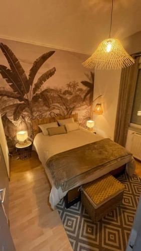 - une chambre avec un lit et une fresque murale de palmiers dans l'établissement La VILLA DEKO, à Beuvry