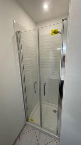 une douche avec une porte vitrée dans une salle de bain dans l'établissement La VILLA DEKO, à Beuvry