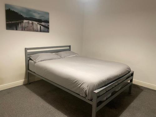 a bed in a bedroom with a picture on the wall at City Residencies - Thames View Greenwich in London