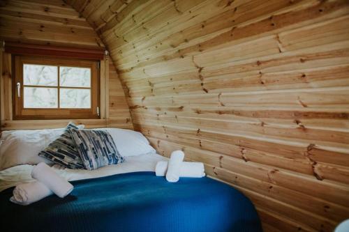 Zimmer mit einem Bett in einem Blockhaus in der Unterkunft Snowdonia Mawddach Cabin + hot tub in Barmouth