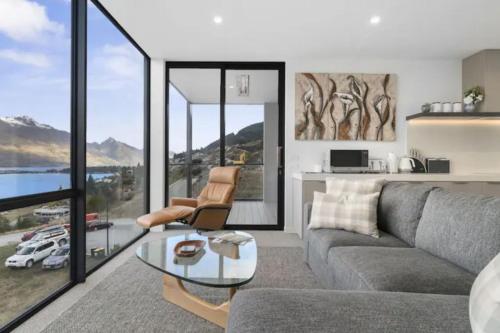 uma sala de estar com um sofá e uma mesa de vidro em Queenstown Terrace em Queenstown