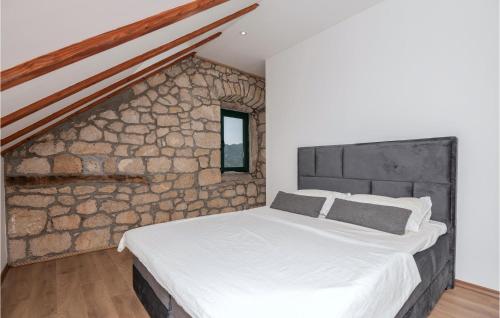 Ce lit se trouve dans un dortoir doté d'un mur en pierre. dans l'établissement Beautiful Home In Vrgorac With Wifi, à Vrgorac