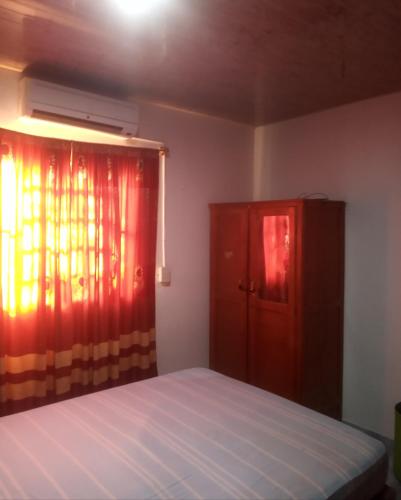 ein Schlafzimmer mit einem Bett und einem roten Vorhang in der Unterkunft Grahl house in Encarnación