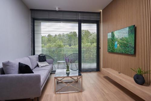 a living room with a couch and a large window at Apartamenty Olimpijska by RENT4YOU in Olsztyn