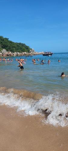 a group of people in the water at the beach at Hospede Mar Bombinhas in Bombinhas