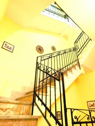 a spiral staircase with a metal railing in a building at Il Portico Rosa in Cuglieri