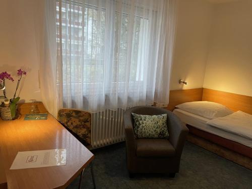 a hotel room with a bed and a chair and a window at Cascade in Stuttgart