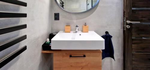 a bathroom with a white sink and a mirror at Villa-Piccoló Siófok (privát szaunával) in Siófok