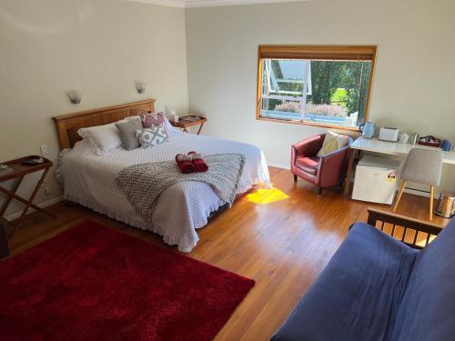 a bedroom with a bed and a desk and a chair at Coastal Lodge Kekerengu in Kekerengu
