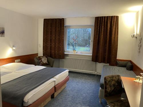 een hotelkamer met een bed, een bureau en een raam bij Cascade in Stuttgart