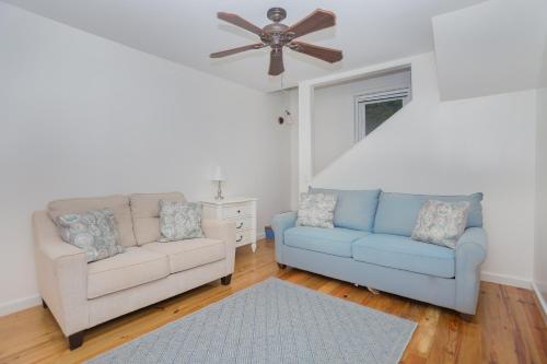 a living room with two couches and a ceiling fan at Casa de Suenos Home in Sandy Bay
