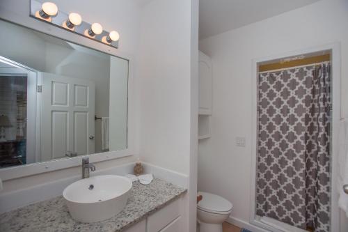 a white bathroom with a sink and a mirror at Casa de Suenos Home in Sandy Bay