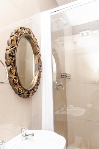 a bathroom with a mirror and a sink and a shower at Nkosazana Guest House in Durban