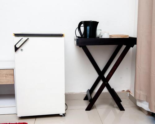 a table next to a side table with a refrigerator at Nkosazana Guest House in Durban