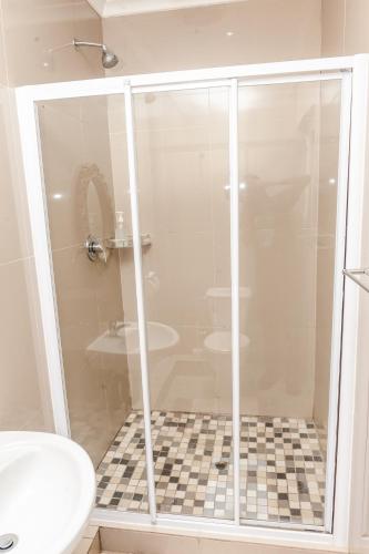 a shower in a bathroom with a toilet and a sink at Nkosazana Guest House in Durban