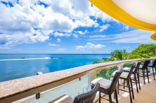Un balcón con sillas y vistas al océano. en Del Playa Penthouse #5 Condo, en West End