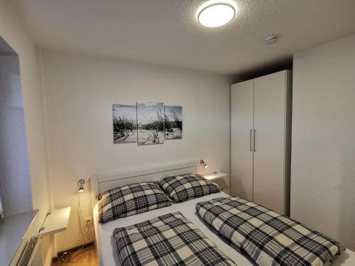 um quarto com uma cama com duas almofadas xadrez em Strandsegel em Horumersiel